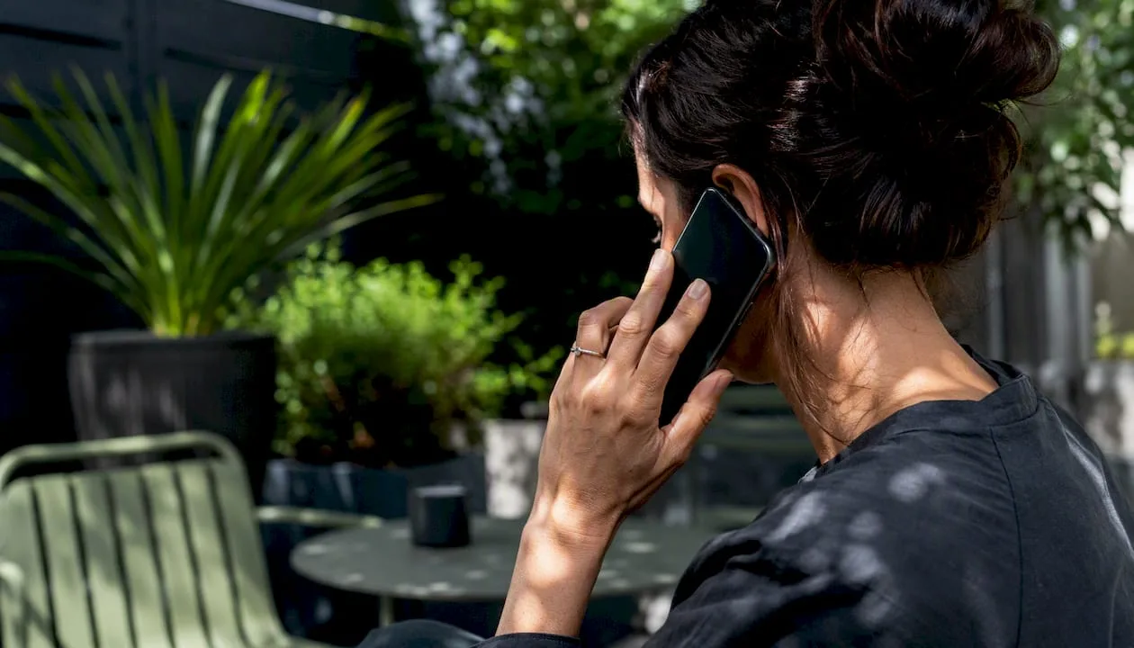Hand holding phone listening to voicemail