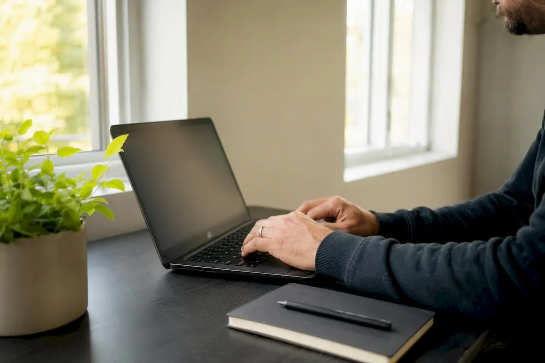 Hands sending brief email on laptop