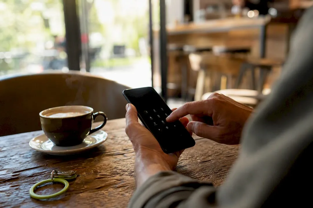 Hand pressing phone keypad confirming call consent